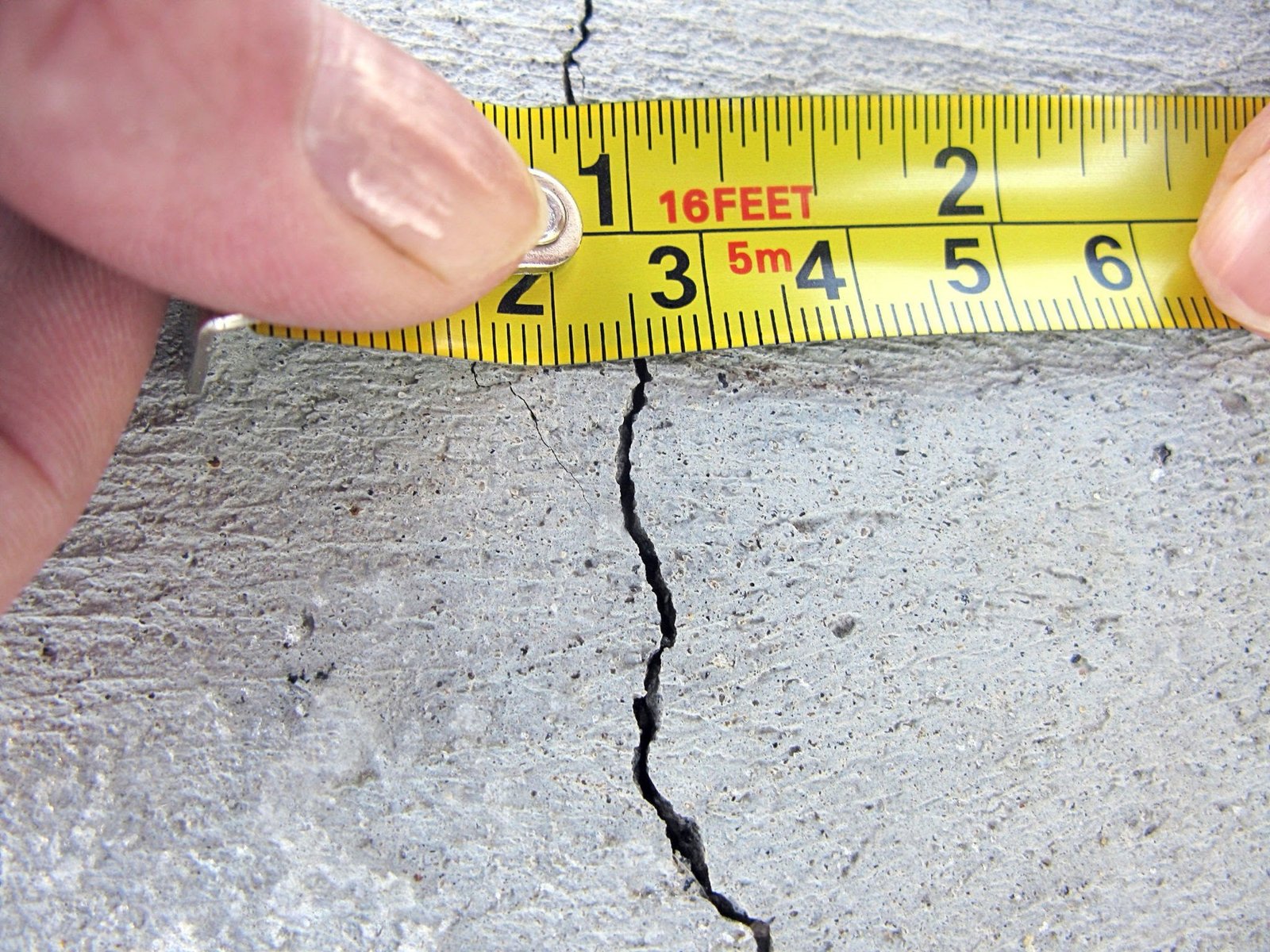 Tape measure across a crack in a concrete slab